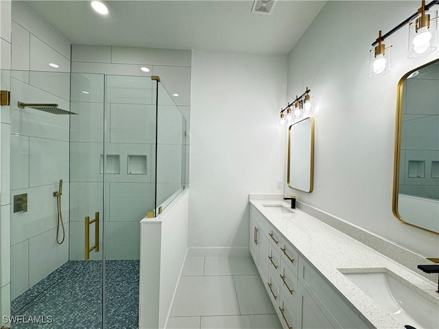 bathroom featuring visible vents, a sink, a shower stall, and tile patterned floors