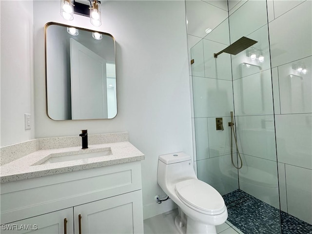 full bath featuring a tile shower, vanity, and toilet