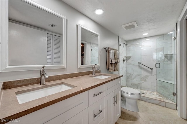 bathroom with visible vents, a sink, a shower stall, and toilet