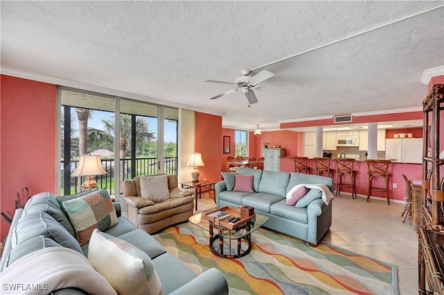 tiled living area with floor to ceiling windows, crown molding, visible vents, a ceiling fan, and a textured ceiling