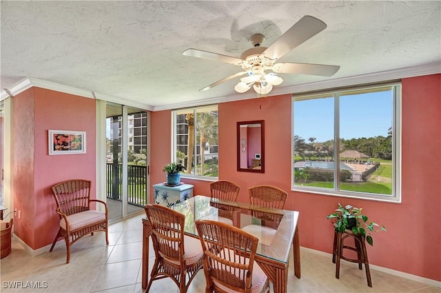 dining area with ornamental molding, light tile patterned flooring, a textured ceiling, and baseboards