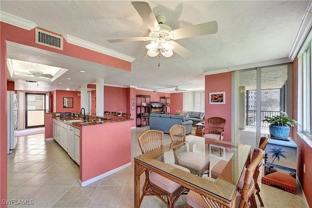 dining area featuring crown molding, visible vents, light tile patterned flooring, ceiling fan, and a textured ceiling