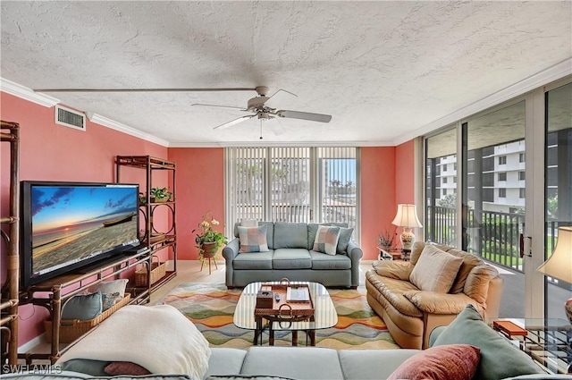 living room with ceiling fan, visible vents, a textured ceiling, and ornamental molding