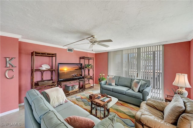 living area with baseboards, visible vents, ornamental molding, and a textured ceiling