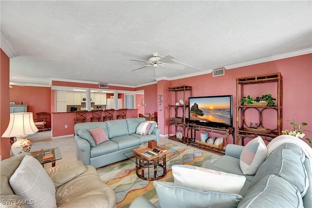 living area with a ceiling fan, visible vents, and crown molding