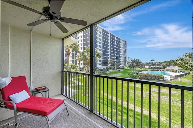 balcony featuring a sunroom and a ceiling fan