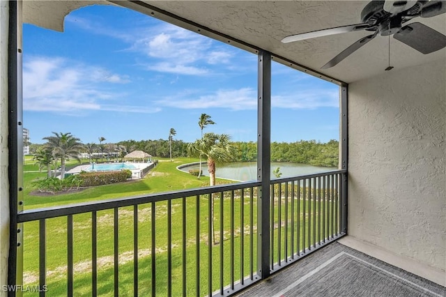 balcony featuring a water view and a ceiling fan