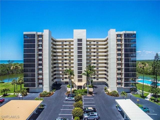 view of property with uncovered parking and a water view