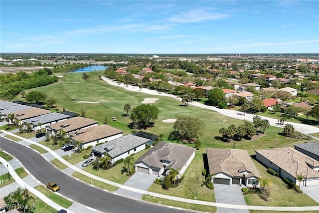 aerial view with view of golf course, a water view, and a residential view