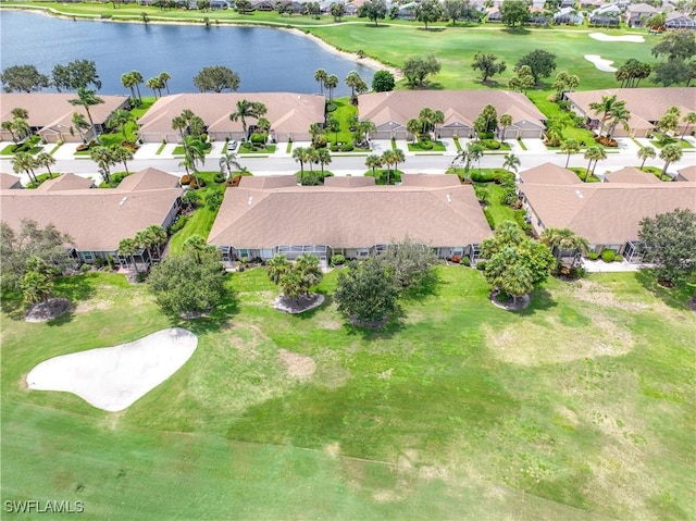 drone / aerial view featuring golf course view, a water view, and a residential view