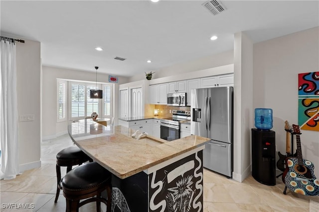 kitchen featuring white cabinets, visible vents, stainless steel appliances, and a sink