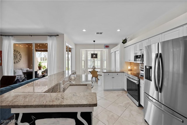 kitchen featuring visible vents, stainless steel appliances, a sink, and a wealth of natural light