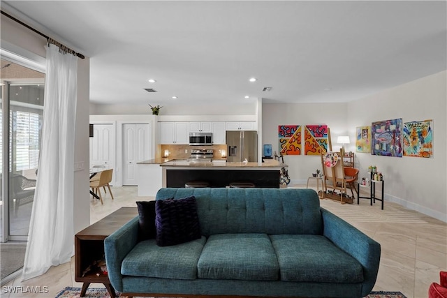 living area featuring baseboards, visible vents, and recessed lighting