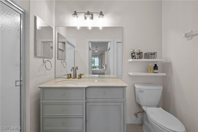 bathroom with a shower stall, vanity, and toilet