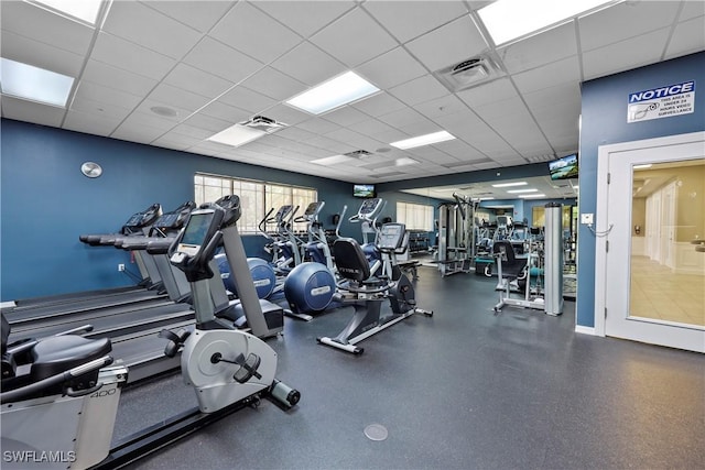 gym with a paneled ceiling and visible vents