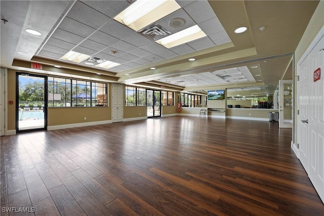 spare room featuring baseboards, a tray ceiling, and wood finished floors