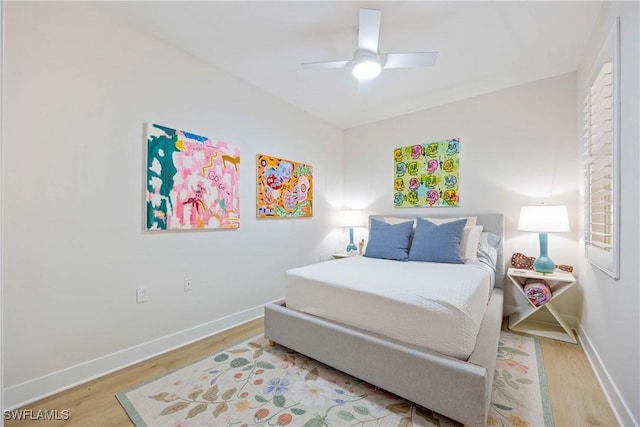 bedroom with a ceiling fan, baseboards, and wood finished floors