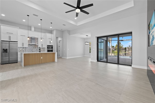 unfurnished living room with visible vents, a ceiling fan, a sink, recessed lighting, and baseboards