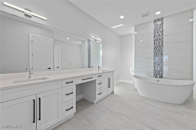 full bathroom featuring a freestanding bath, double vanity, visible vents, and a sink