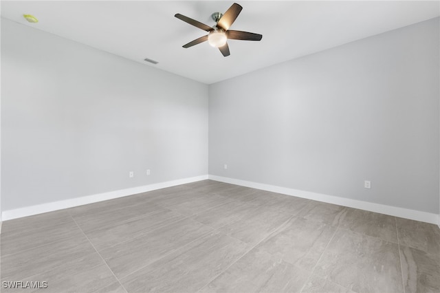 unfurnished room featuring visible vents, a ceiling fan, and baseboards