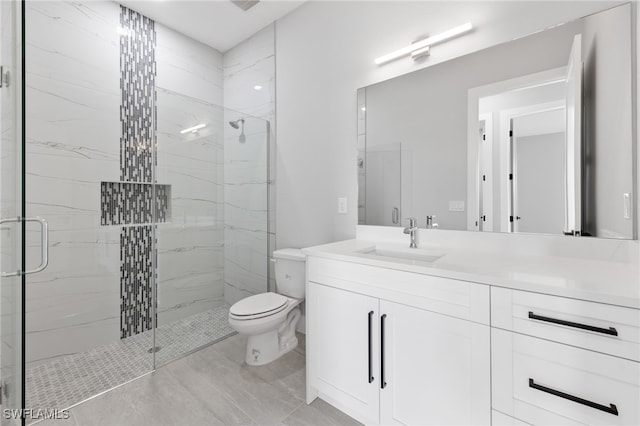 full bath with vanity, toilet, and a marble finish shower