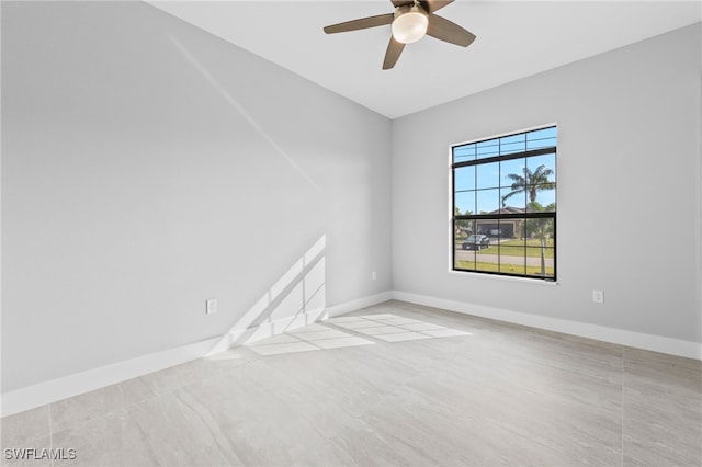 unfurnished room featuring a ceiling fan and baseboards