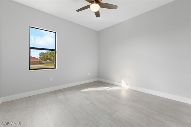 spare room featuring ceiling fan and baseboards