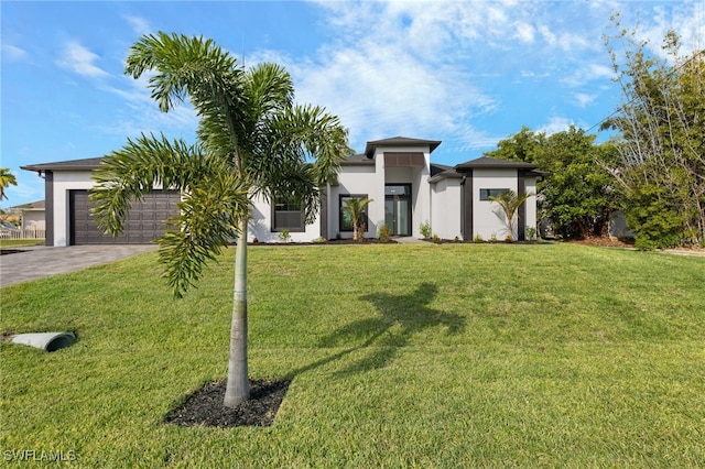 view of front of house featuring stucco siding, a front lawn, a garage, and driveway