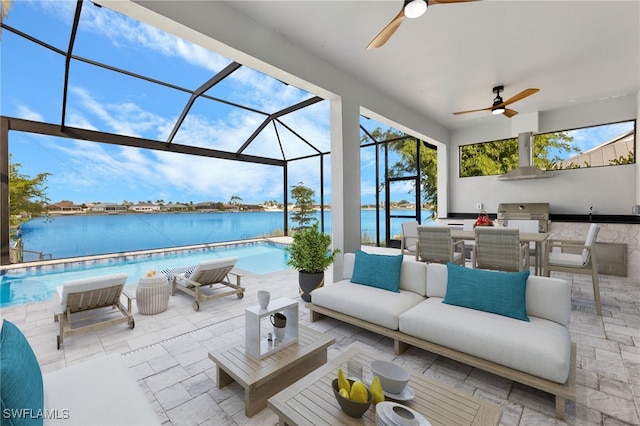 view of patio / terrace featuring a water view, exterior kitchen, an outdoor pool, an outdoor hangout area, and a lanai