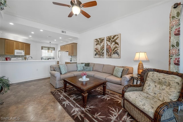 living area featuring visible vents, baseboards, ornamental molding, recessed lighting, and a ceiling fan