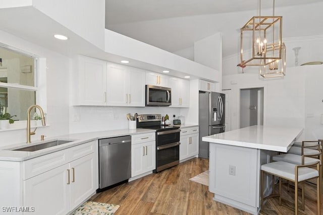 5311 Harborage Dr, Fort Myers, FL 33908 - kitchen with appliances with stainless steel finishes, a sink, high vaulted ceiling, a kitchen bar, and white cabinets