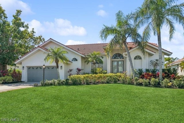 5311 Harborage Dr, Fort Myers, FL 33908 - mediterranean / spanish house featuring a front yard, a garage, a tiled roof, concrete driveway, and stucco siding