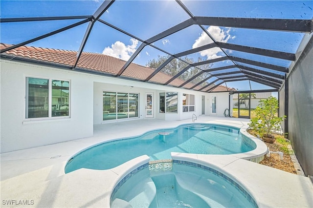 view of swimming pool featuring glass enclosure, a pool with connected hot tub, and a patio