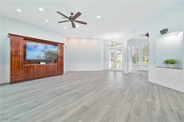 unfurnished living room featuring a wainscoted wall, light wood finished floors, ceiling fan with notable chandelier, and recessed lighting