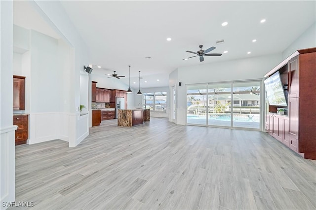 unfurnished living room featuring visible vents, a ceiling fan, light wood-style flooring, a sink, and recessed lighting