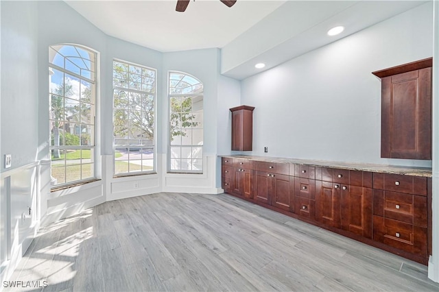 bathroom with a ceiling fan, recessed lighting, a decorative wall, and wood finished floors