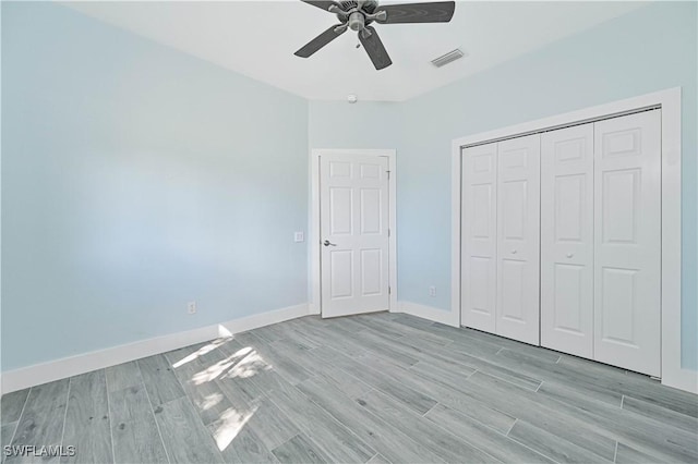 unfurnished bedroom with a ceiling fan, baseboards, visible vents, light wood-style floors, and a closet