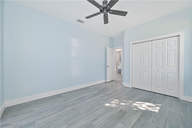 unfurnished bedroom with light wood finished floors, baseboards, visible vents, ceiling fan, and a closet