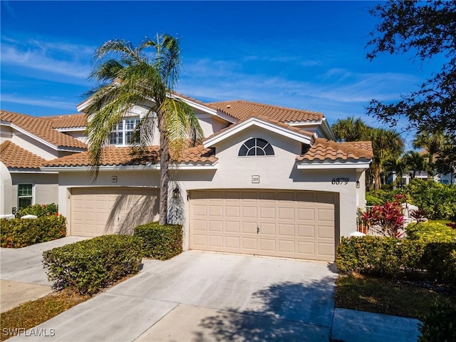 view of front facade featuring stucco siding, concrete driveway, an attached garage, and a tile roof