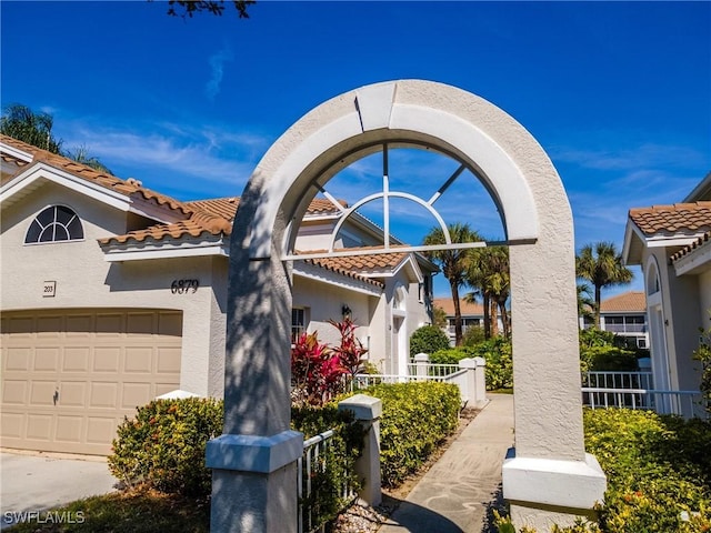 view of front of house with stucco siding, a tile roof, and a garage