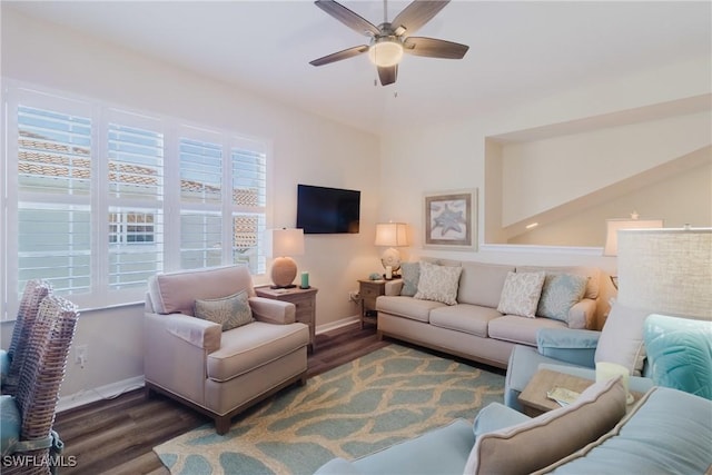 living area featuring baseboards, a ceiling fan, and wood finished floors