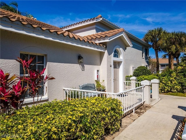 view of front of home featuring a tile roof and stucco siding