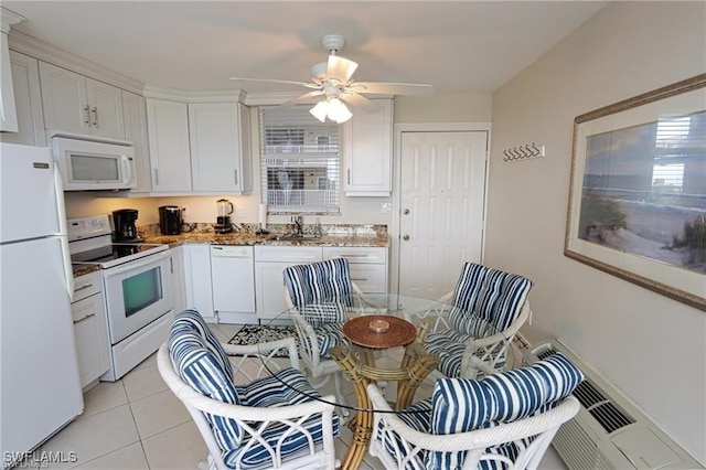 kitchen with white appliances, white cabinetry, a sink, and light tile patterned floors