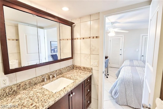 ensuite bathroom with tile walls, decorative backsplash, ceiling fan, connected bathroom, and tile patterned floors