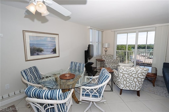 tiled dining area featuring ceiling fan and baseboards