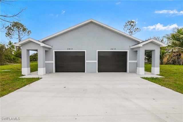 view of front of house with a garage, a front lawn, and stucco siding