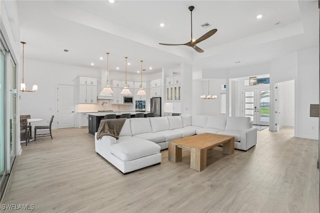 living area featuring a chandelier, ceiling fan, light wood-style flooring, and recessed lighting
