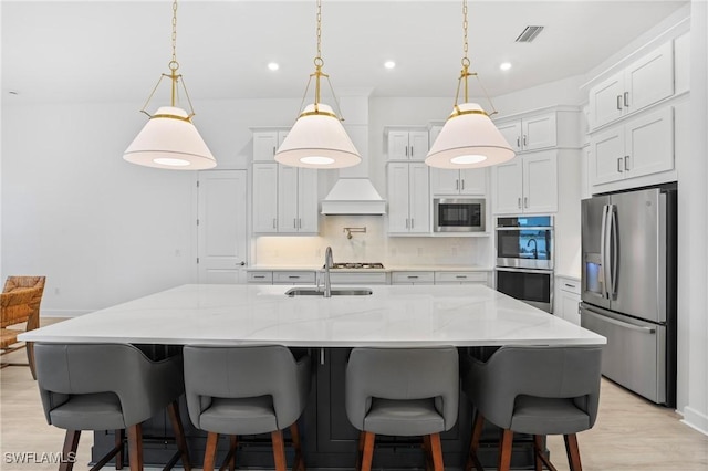 kitchen featuring light wood finished floors, visible vents, backsplash, white cabinets, and appliances with stainless steel finishes