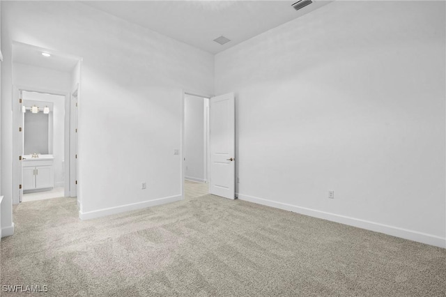 unfurnished bedroom with carpet flooring, connected bathroom, and baseboards