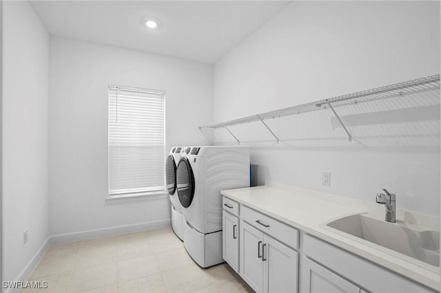 laundry area with a sink, separate washer and dryer, cabinet space, and baseboards